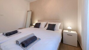 A hotel room with a large bed, two bedside tables, a nightstand, and a mirror. - Pet friendly home in Labin (Labin)