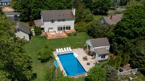 Il s’agit d’une propriété résidentielle dotée d’une piscine, d’un patio avec des chaises longues et d’un jardin.