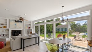 Un vaste espace de vie comprenant une grande fenêtre, une table à manger et un canapé.