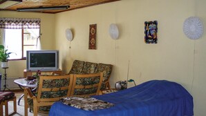 Une chambre à coucher avec un lit, une télévision, un bureau et une chaise.