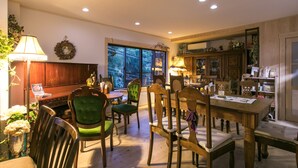A dining area with wooden furniture, a chandelier, and a view through large windows. - Houtouji Temple (Yoshino)