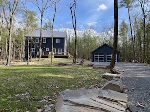 Situated in a wooded area, this two-story home offers a serene view from its front deck.