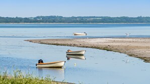 Un lac paisible, avec des bateaux et une plage de sable.