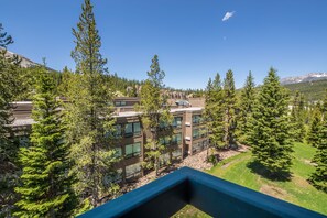 A modern hotel with multiple floors, surrounded by lush greenery and mountains in the background. - Ski in/out w/stunning views, fireplace, community pool/hot tub! - Shoshone Ski Haus (Big Sky)