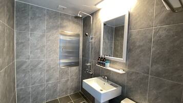 A modern bathroom with a shower, sink, and toilet.