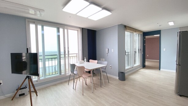 A modern apartment with a balcony, a dining area, and a kitchen.