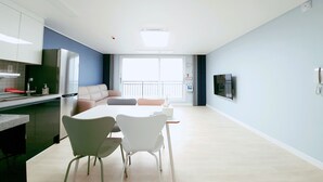 A modern apartment with a kitchen, dining area, and living space.