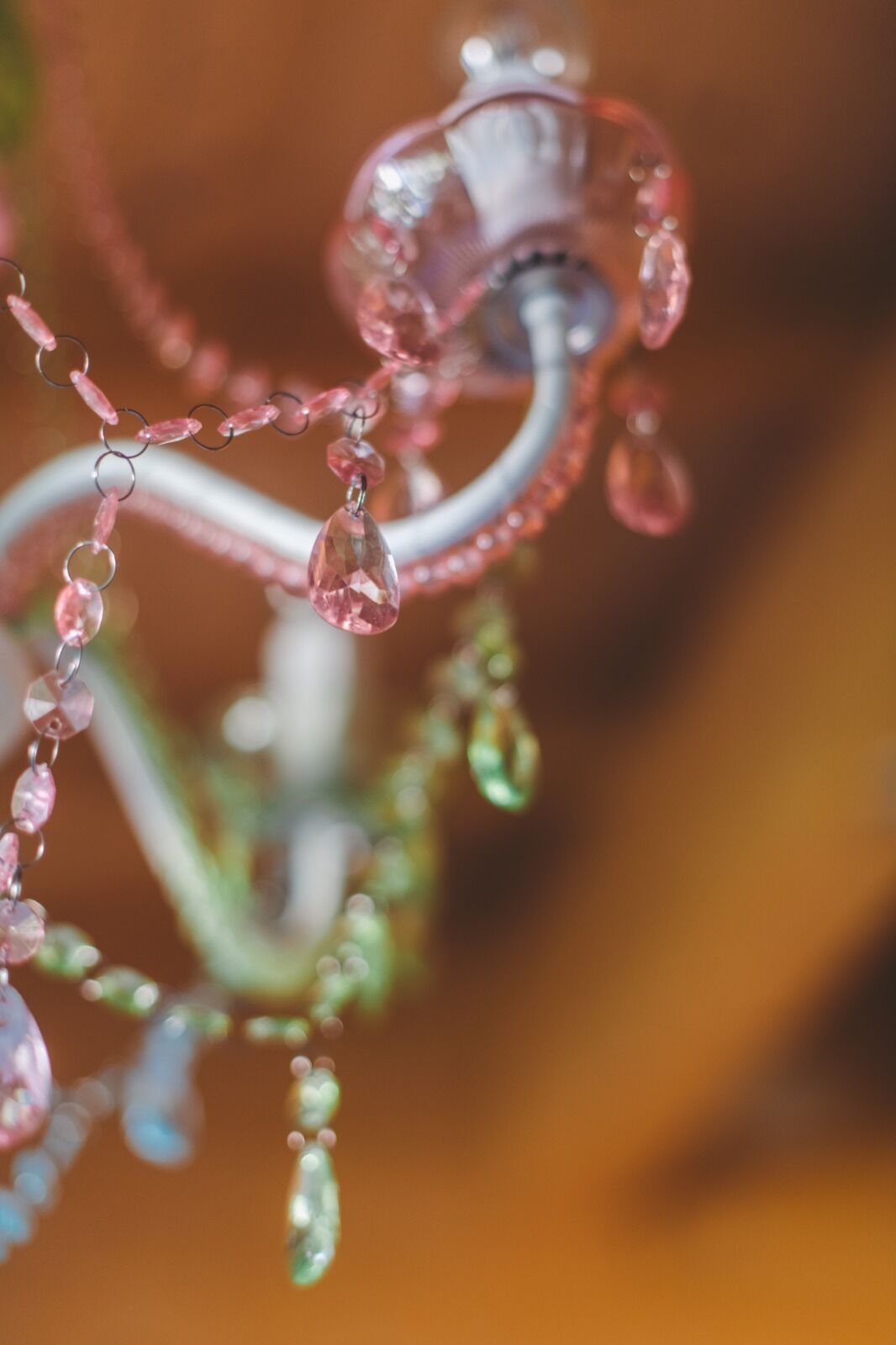 A close-up of a decorative item with pink and green elements, possibly a piece of jewelry or ornament.