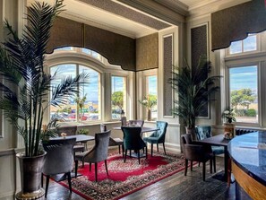 A spacious room with large windows, elegant furniture, and lush plants. - Queen s Hotel (Portsmouth)