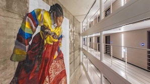 A corridor with a modern interior, featuring a glass railing and a view of a building across the corridor. - Busan Yeongmu Parade Hotel Haeundae Beach (Busan)