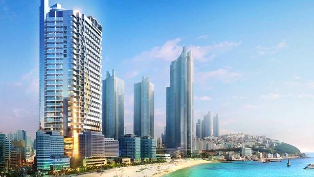 A coastal cityscape with high-rise buildings, a beach, and a clear sky. - Busan Yeongmu Parade Hotel Haeundae Beach (Busan)
