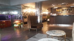 Un vestíbulo de hotel con recepción, zona de estar y bar.