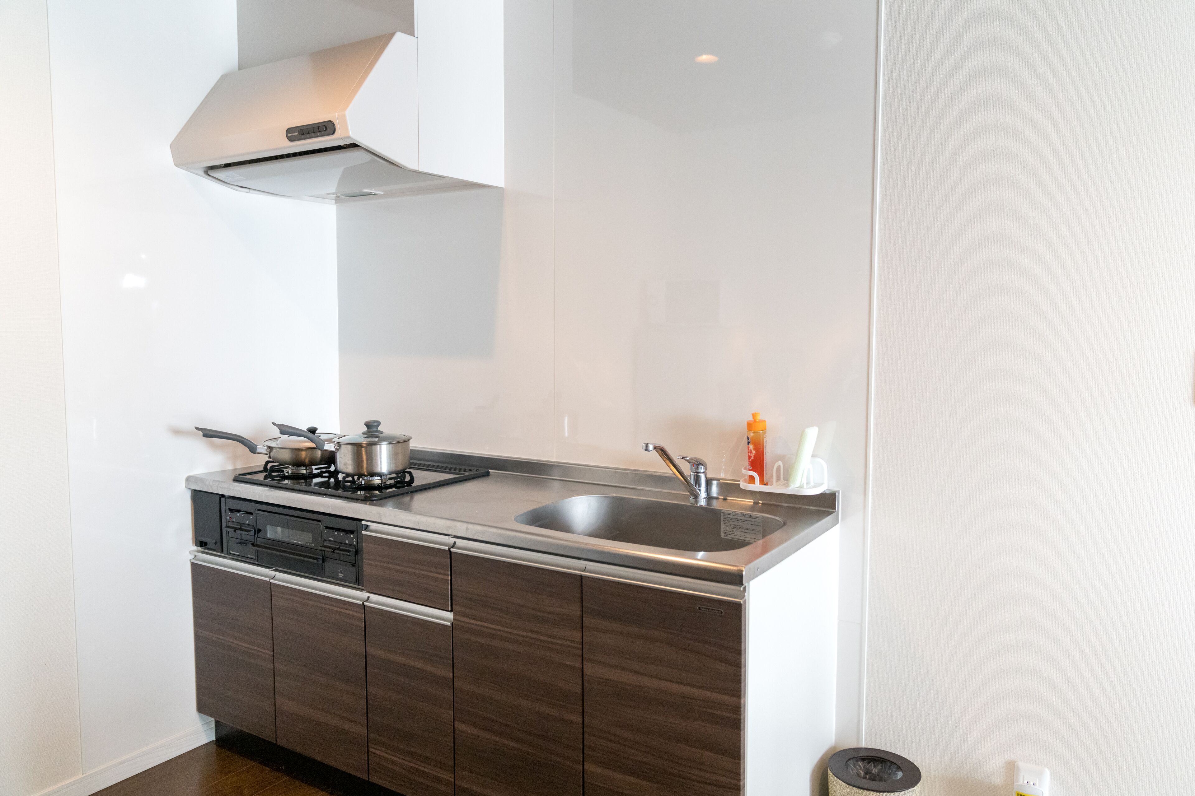 A modern kitchen with a stainless steel stove, sink, and wooden cabinets.