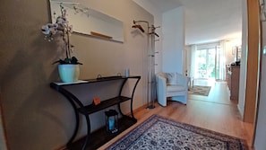 Ein modernes Wohnzimmer mit einer Couch, einem Couchtisch, einer Stehlampe und einem großen Fenster.