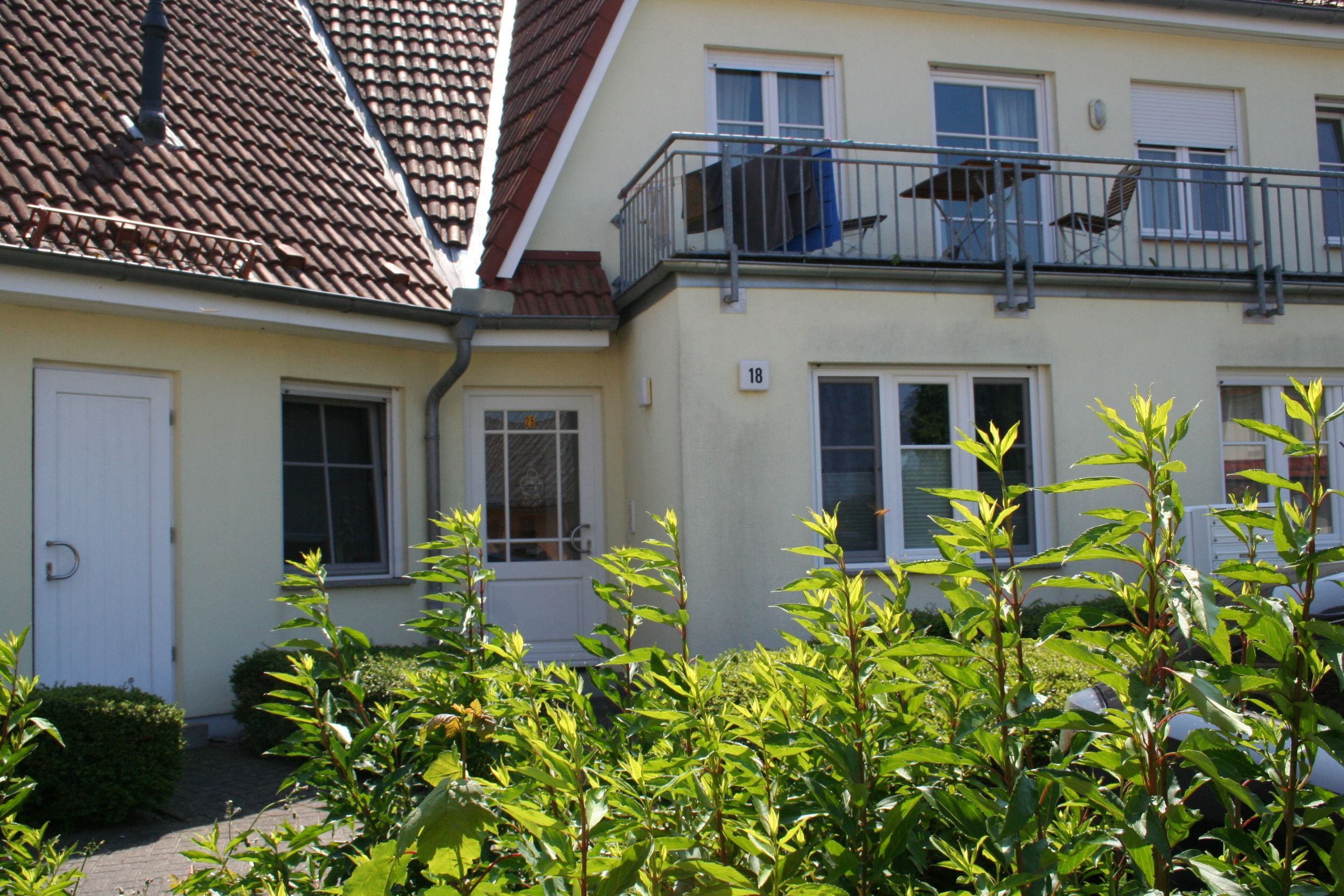 Un bâtiment à deux étages doté d’un balcon, d’une porte et de fenêtres.