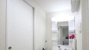 A small, clean bathroom with a white sink, dark cabinets, and a mirror above the sink.