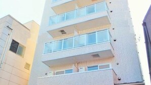 A multi-story building with a modern design, featuring balconies on each floor.