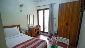 A hotel room with a bed, a desk, a chair, a wardrobe, and a balcony with a view. - Al Karnak Hotel (Dubai)