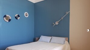 Een slaapkamer met een bed, een blauwe wand en een decoratieve wandversiering.