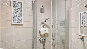 Un bagno moderno con doccia vetro, un water e un lavandino con specchio sopra.