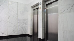 A modern elevator with marble walls and a black-tiled floor. - Design Gardens, a Home in Madeira (Funchal)