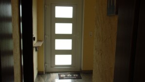 Un corridoio con una porta che presenta un motivo in vetro satinato.