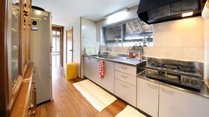 Een kleine keuken met een koelkast, fornuis en spoelbak.