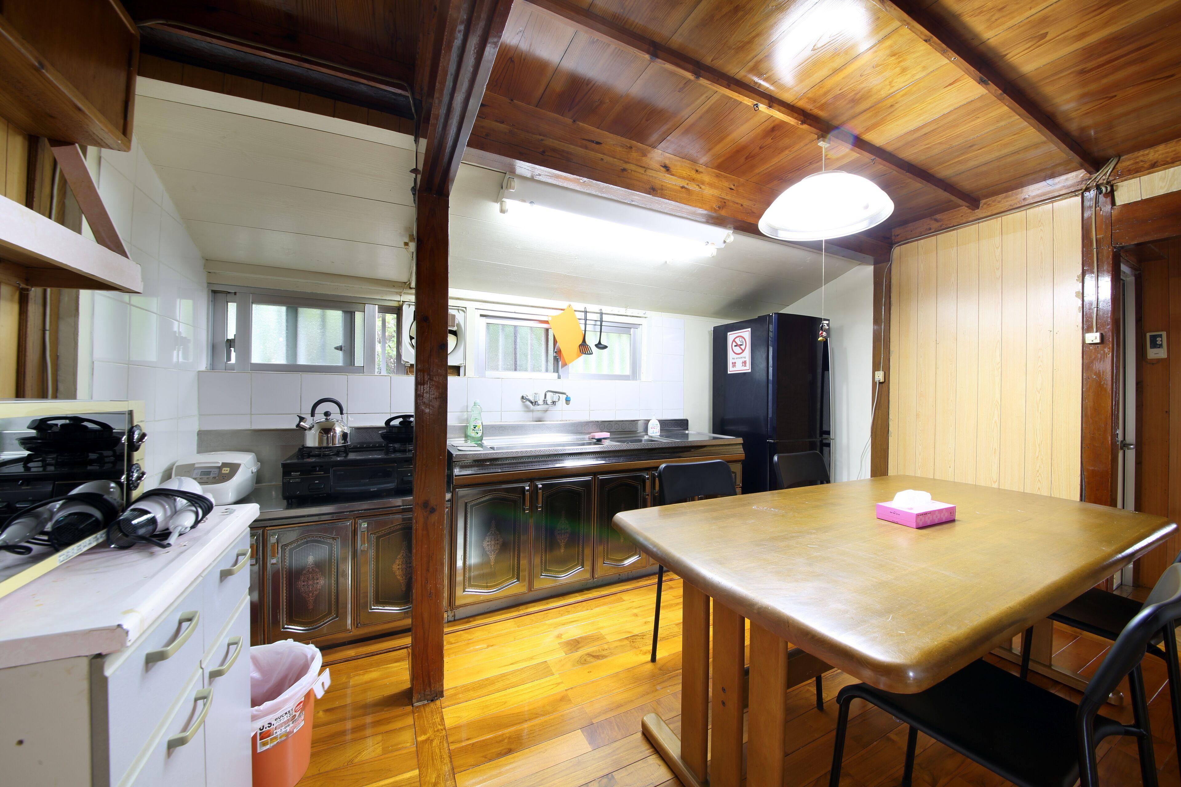 A kitchen with wooden cabinets, a stove, and a table with a chair.