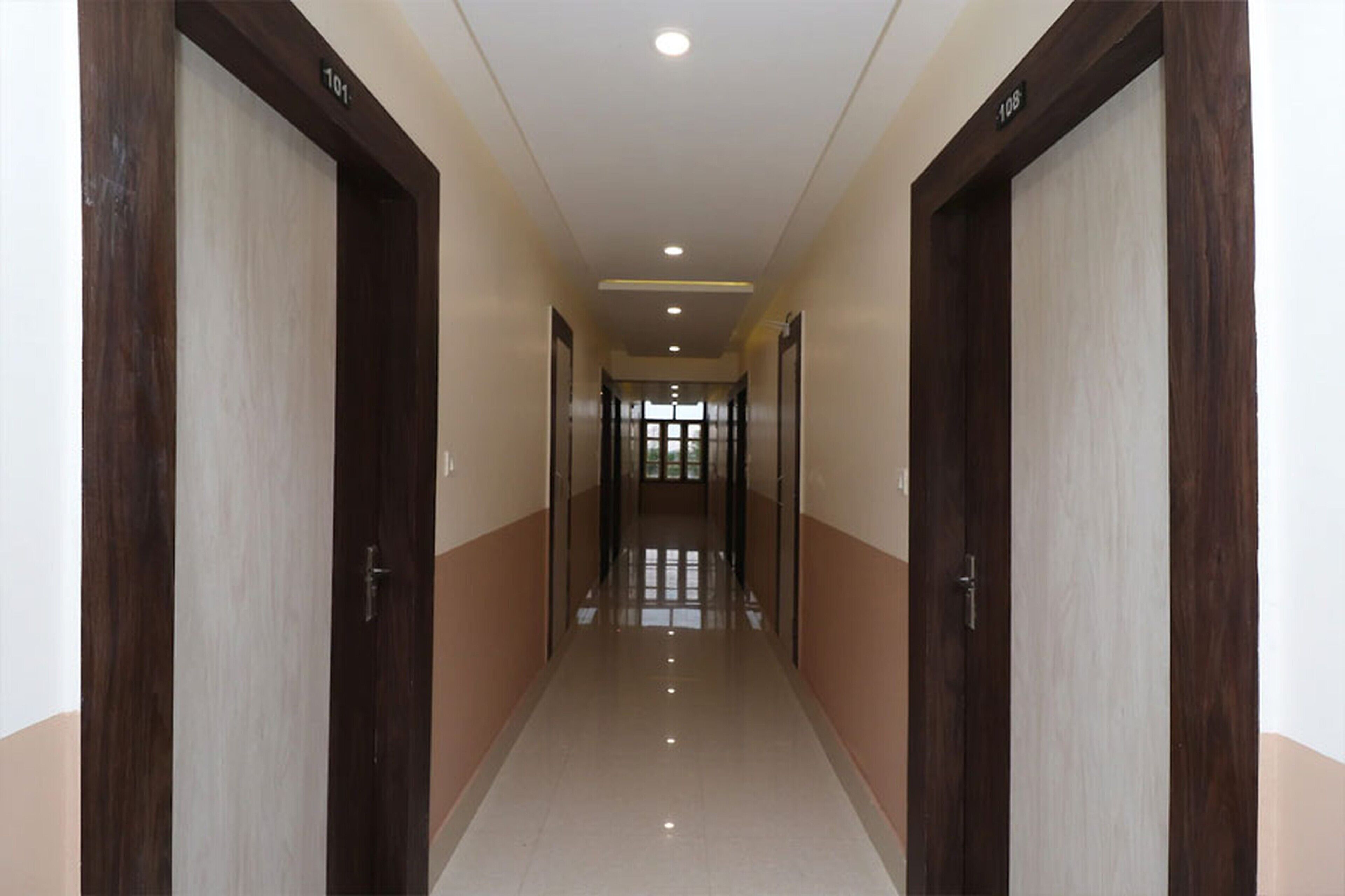 A hallway with doors labeled 101 and 108, leading to a bright room with a large window.