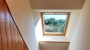 A wooden staircase with a skylight and a framed picture of a lighthouse. - House with sauna. Internet, Comfortable, Beaches 5mn. Golf 2mn (Lamballe Armor)