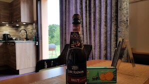 A bottle of Loïc Raison Brut Intense wine on a table with a box of cookies. - House with sauna. Internet, Comfortable, Beaches 5mn. Golf 2mn (Lamballe Armor)
