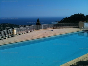 Ein Schwimmbecken mit Blick aufs Meer und einem weißen Zaun.
