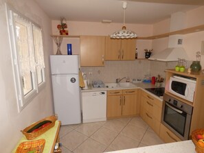 A compact kitchen with a refrigerator, sink, microwave, and oven.