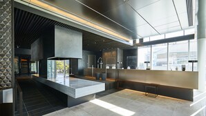 Un interior moderno con una isla central, iluminación empotrada y grandes ventanales.