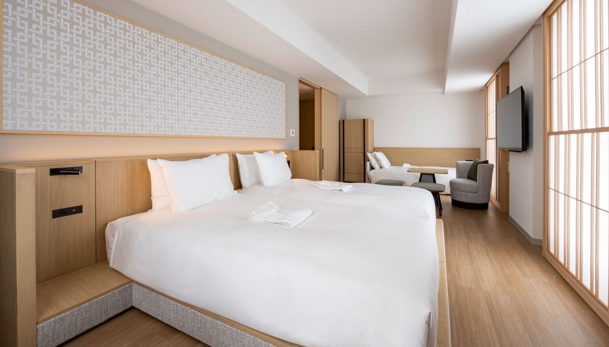 Een hotelkamer met een groot bed, een bureau, een stoel en een televisie.