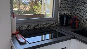 Eine Küche mit Fenster, Spüle, Herd und Mikrowelle.
