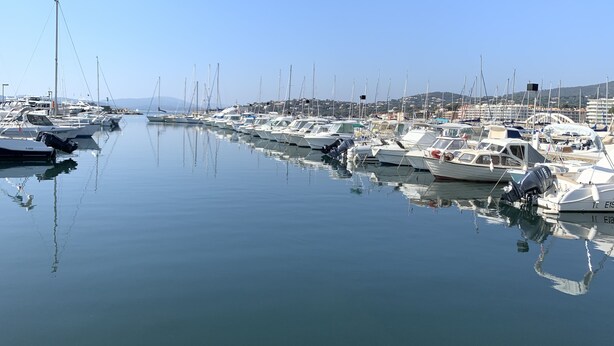 Eine Marina mit zahlreichen Booten, die in ruhigem Wasser vor Anker liegen.