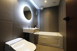 Un baño moderno con inodoro, lavamanos y bañera.