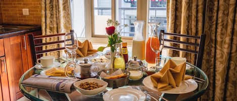 Una mesa de desayuno dispuesta con diferentes platos, bebidas y un periódico.