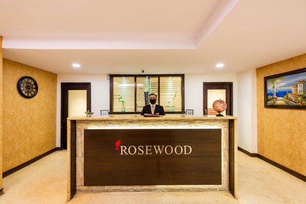 A reception desk with the name "ROSEWOOD" prominently displayed. - Rosewood Apartment Hotel - Pantnagar (Kichha)