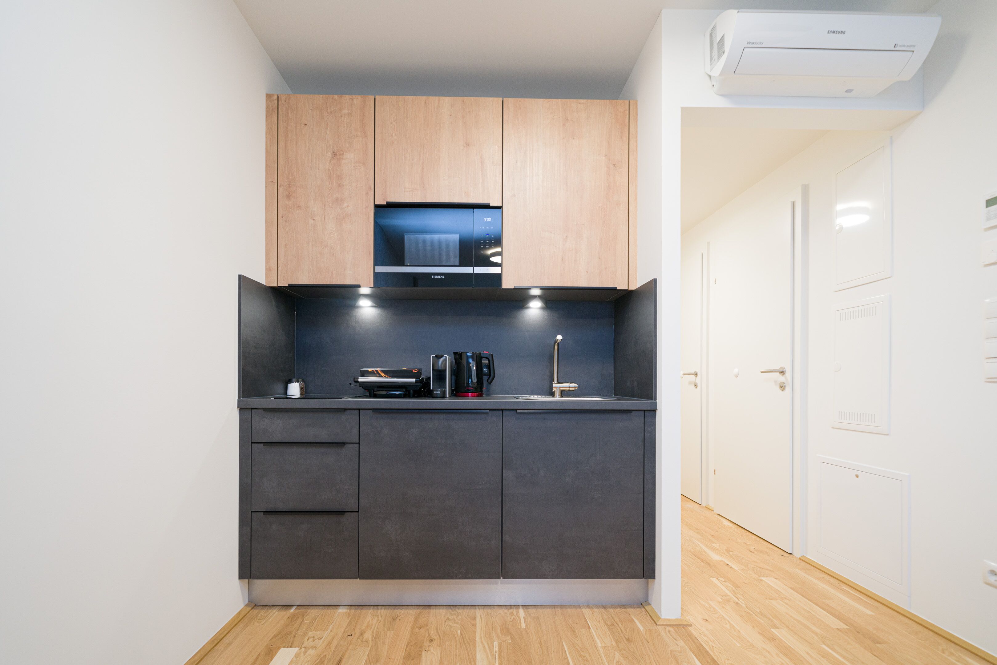 A compact kitchen with dark cabinets, a microwave, and a coffee maker.