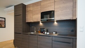 Una cocina moderna con armarios de madera, un microondas integrado y una cafetera en la encimera.