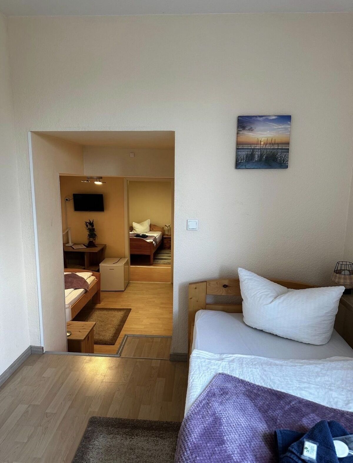 A hotel room with a bed, a desk, a chair, and a TV.