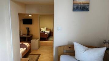 A hotel room with a bed, a desk, a chair, and a TV.