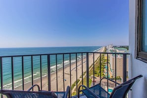 Ein Balkon mit Blick auf Strand und Meer.