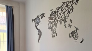 A meeting room with a geometric world map on the wall, tables, and chairs. - A Plus Hostel - Centrum (Prague)