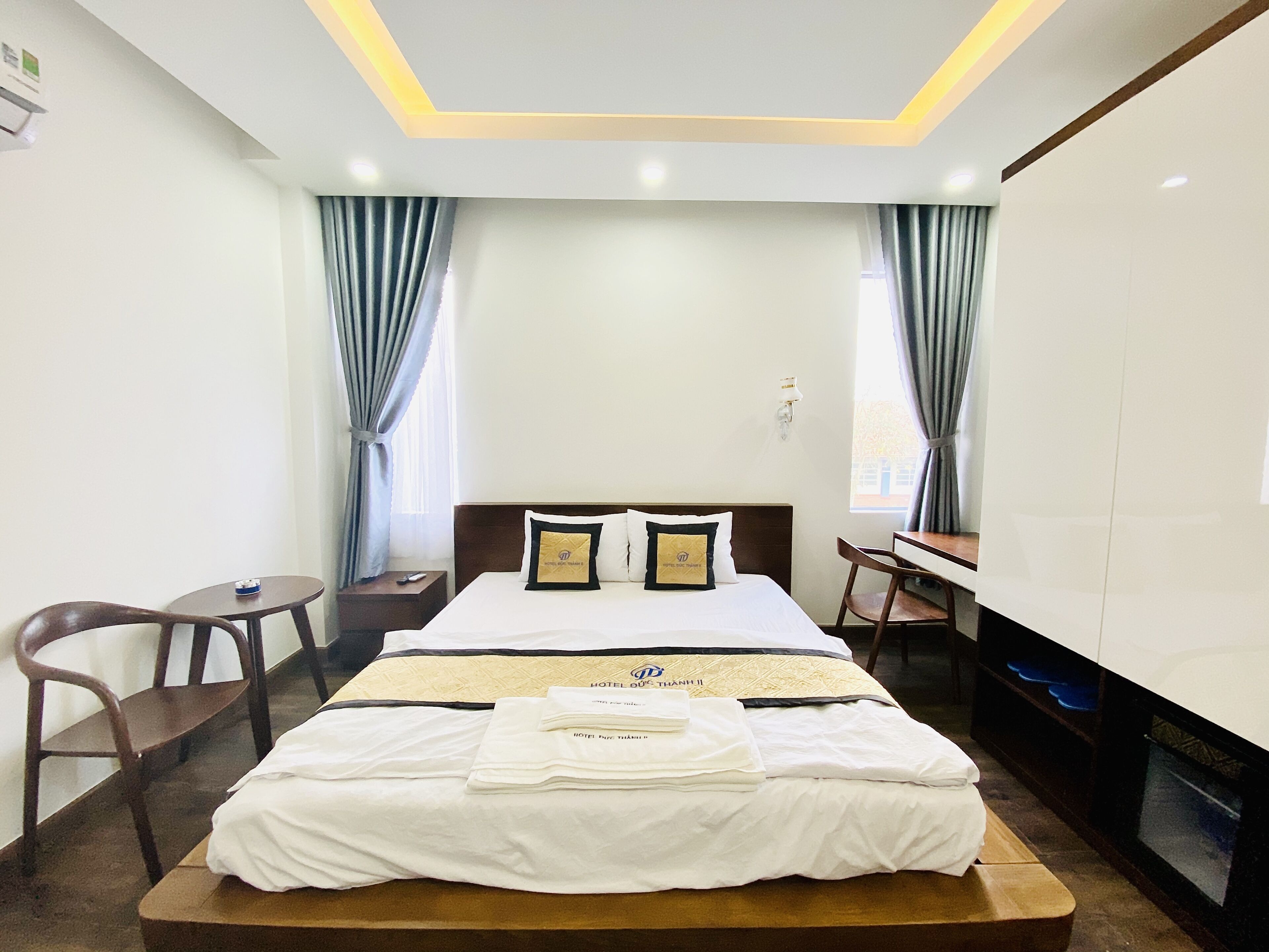 A hotel room with a bed, a desk, a chair, and a TV.