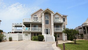 A multi-story residential building with balconies, a gated entrance, and a well-maintained lawn.