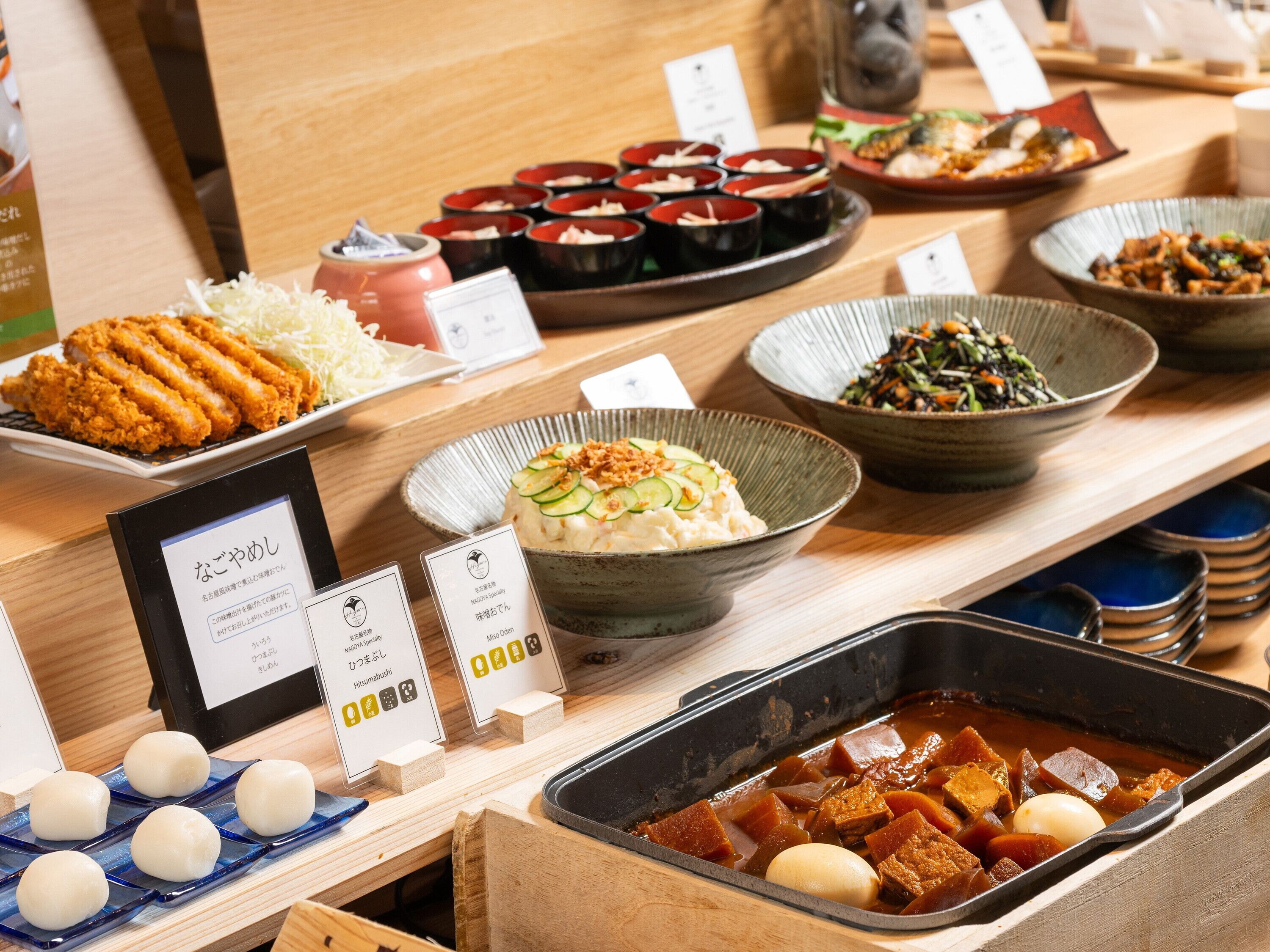 A variety of Japanese dishes displayed on a wooden table, including sushi, tempura, and other traditional foods.
