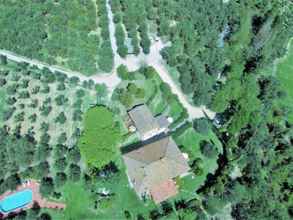 An aerial view of a property with a swimming pool, a large green area, and a building with a red roof. - Villa Bagnano (Certaldo)
